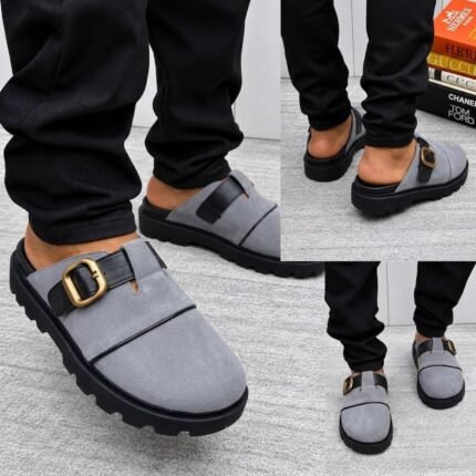 A stylish pair of grey half shoes with a gold buckle and black sole, perfect for adding a touch of luxury to any outfit.