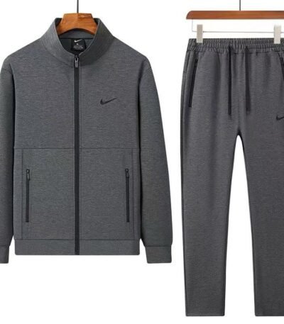 A luxurious Nike tracksuit comprising a zip-up jacket and matching joggers, both in dark grey with black accents, exuding sophistication and high-end athletic wear.