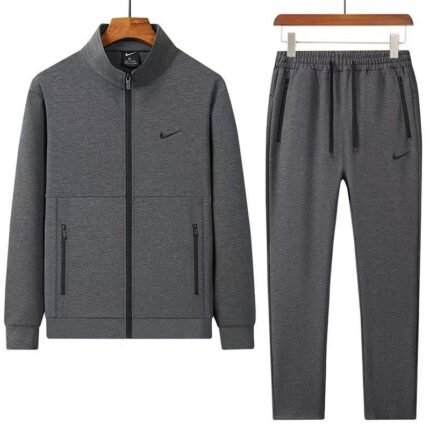 A luxurious Nike tracksuit comprising a zip-up jacket and matching joggers, both in dark grey with black accents, exuding sophistication and high-end athletic wear.