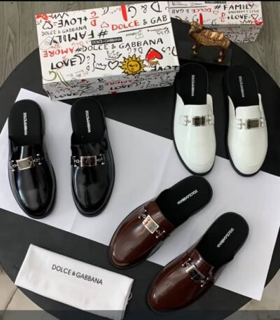 A luxurious display of Dolce & Gabbana half shoes in black, brown, and white, accompanied by the brand's signature box and cloth.
