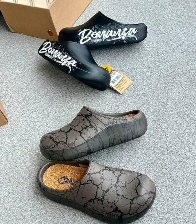 A pair of stylish clogs in black and grey marble finish, showcasing the brand's attention to detail and commitment to quality.