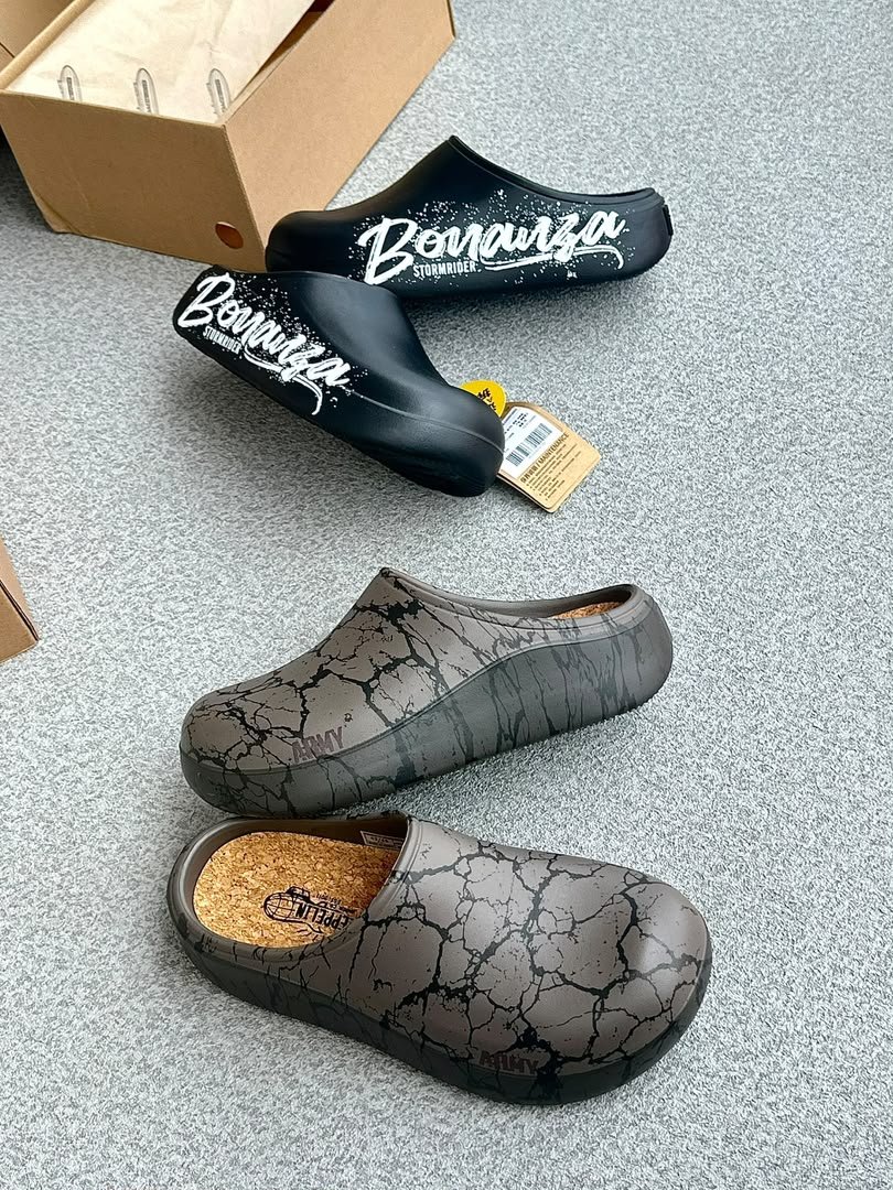 root A pair of stylish clogs in black and grey marble finish, showcasing the brand's attention to detail and commitment to quality.