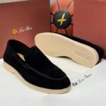 A pair of luxurious black velvet loafers from Loro Piana, showcased with their box and packaging, exuding high-end quality and sophistication.