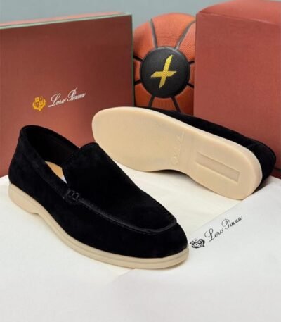 A pair of luxurious black velvet loafers from Loro Piana, showcased with their box and packaging, exuding high-end quality and sophistication.